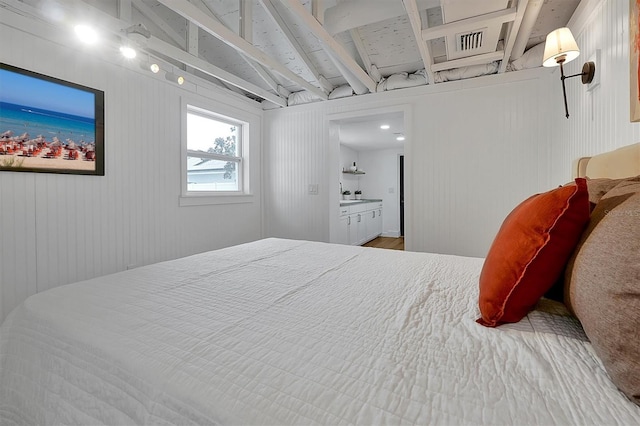 bedroom with connected bathroom, sink, and wood-type flooring