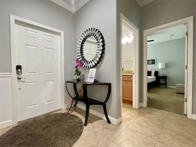 entrance foyer with light tile patterned floors and an inviting chandelier