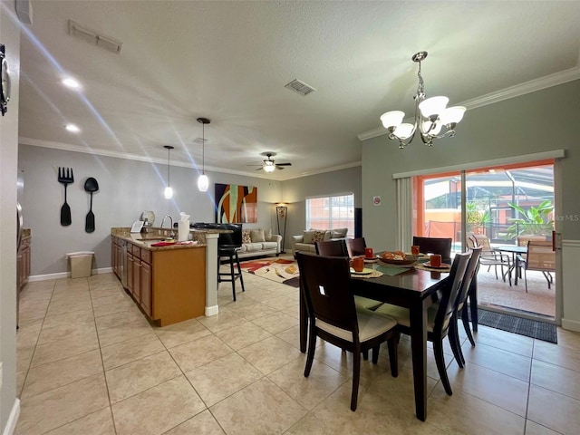 tiled dining area with ornamental molding, ceiling fan with notable chandelier, and sink