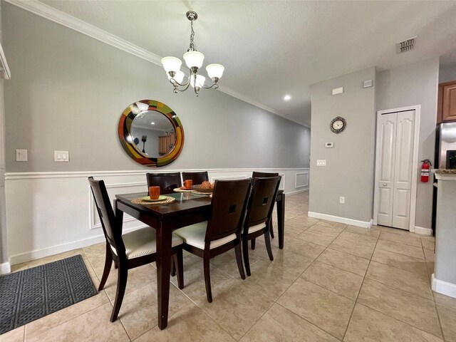 tiled dining room featuring an inviting chandelier, a textured ceiling, and ornamental molding