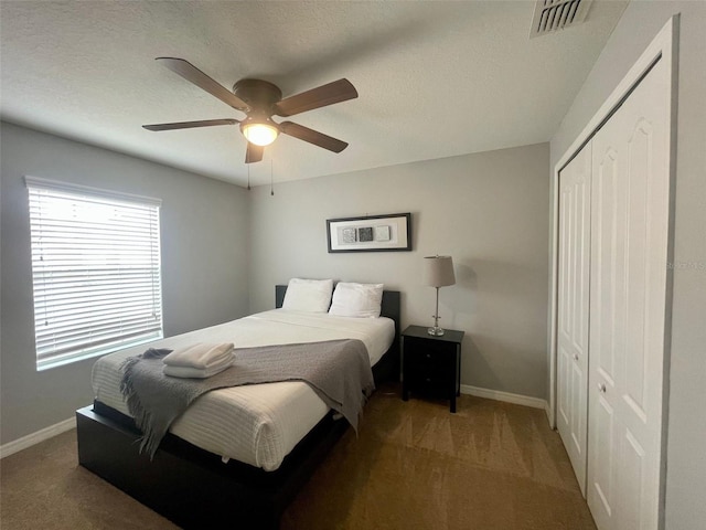 bedroom featuring a textured ceiling, carpet flooring, ceiling fan, and a closet