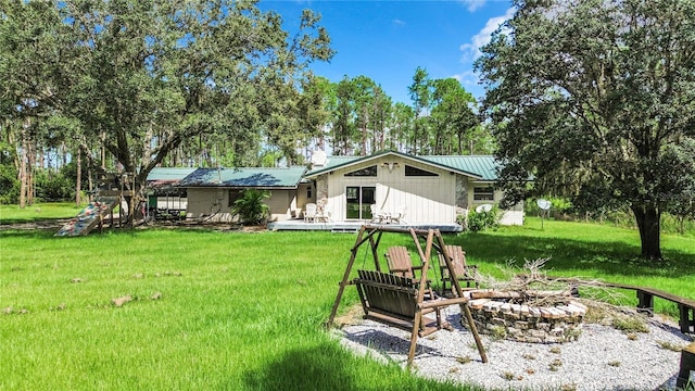 back of house featuring a yard, a patio area, and an outdoor fire pit