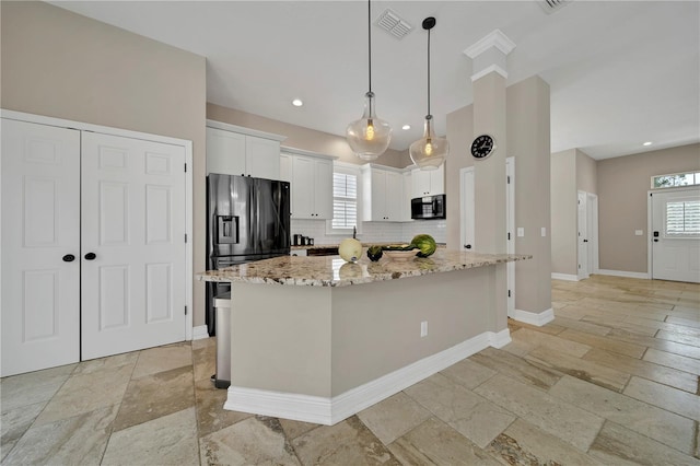 kitchen with a kitchen island, light stone countertops, decorative light fixtures, decorative backsplash, and white cabinets