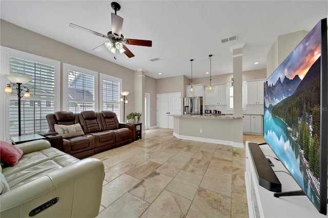 living room featuring ceiling fan and ornate columns