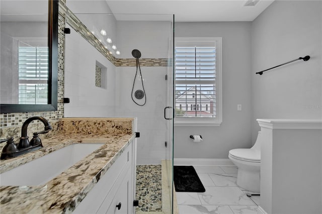 bathroom with vanity, toilet, a healthy amount of sunlight, and walk in shower