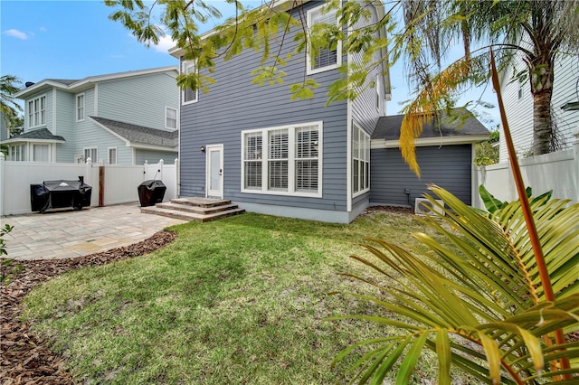 rear view of property featuring a lawn and a patio area