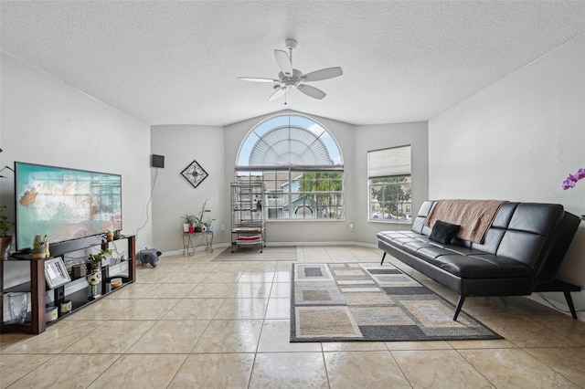 interior space with a textured ceiling, light tile patterned floors, lofted ceiling, and ceiling fan