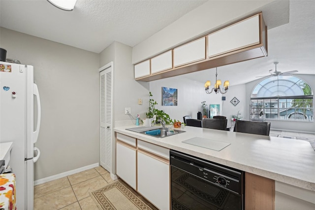 kitchen with white cabinets, white fridge, lofted ceiling, decorative light fixtures, and sink