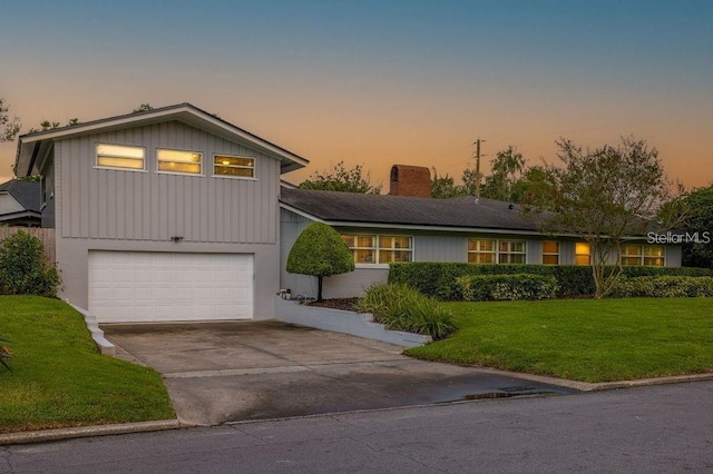 view of front of house with a garage and a yard