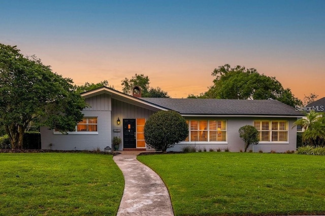 ranch-style home with a yard