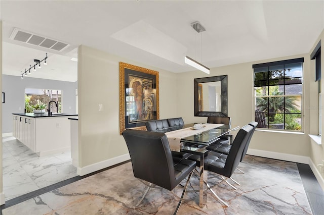 dining room featuring sink and track lighting