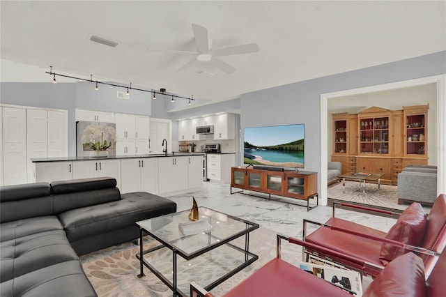 living room featuring rail lighting, sink, and ceiling fan