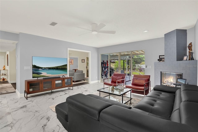 living room with a fireplace and ceiling fan