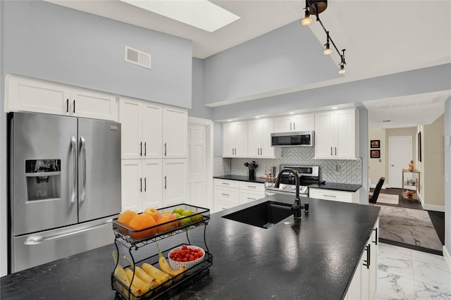 kitchen featuring stainless steel appliances, white cabinetry, a high ceiling, and sink