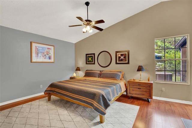 bedroom featuring ceiling fan, light hardwood / wood-style flooring, and high vaulted ceiling