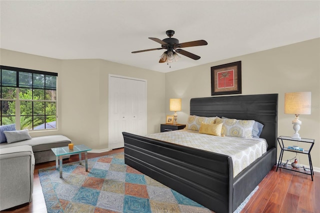 bedroom with dark hardwood / wood-style flooring, ceiling fan, and a closet