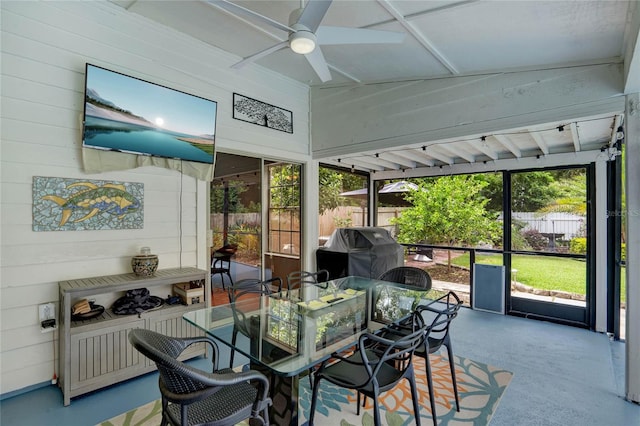 sunroom / solarium featuring ceiling fan, lofted ceiling, and a wealth of natural light