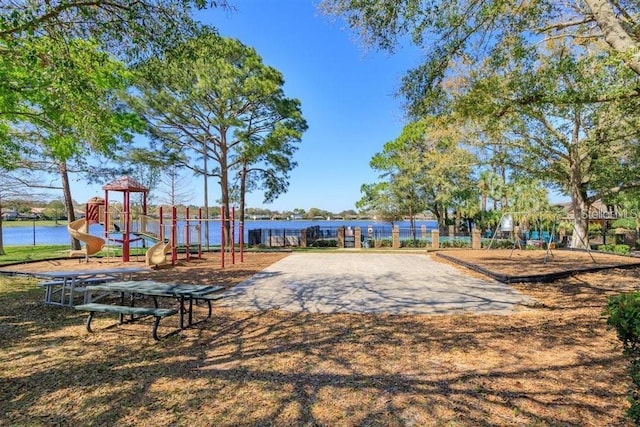 view of community with a playground and a water view