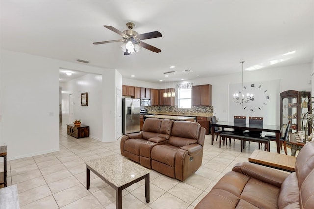 tiled living room featuring ceiling fan with notable chandelier