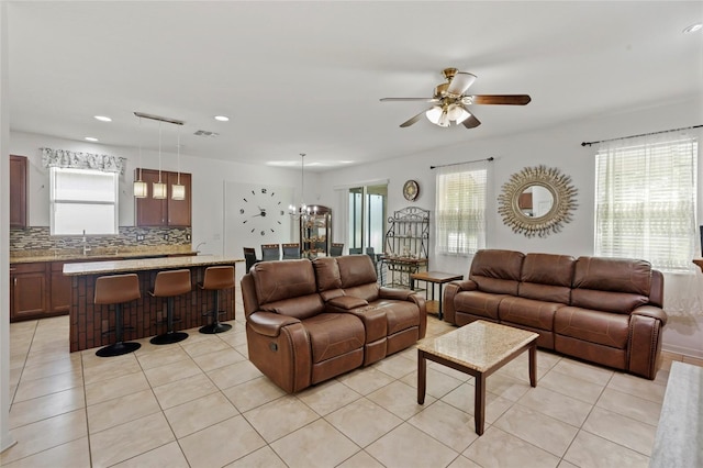 living room featuring sink, ceiling fan with notable chandelier, and light tile patterned flooring