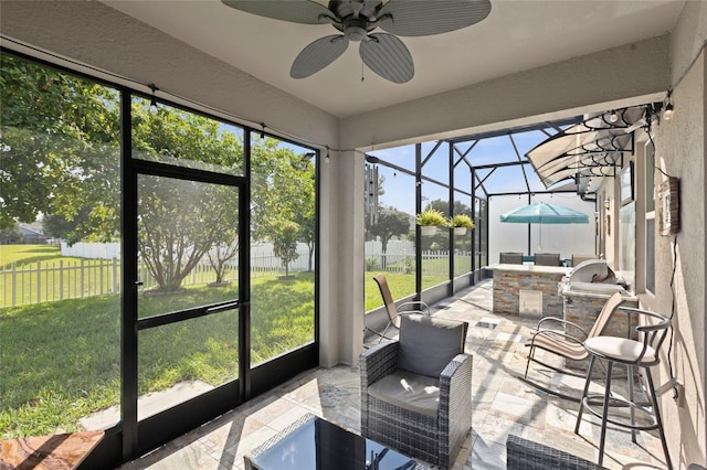 sunroom / solarium featuring plenty of natural light and ceiling fan