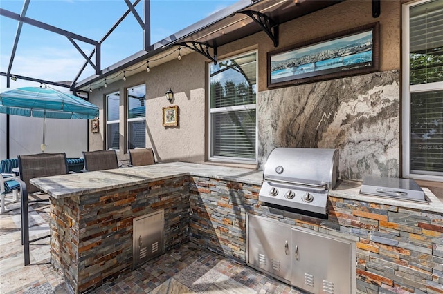 view of patio / terrace with glass enclosure, grilling area, and an outdoor kitchen