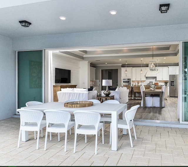 dining room featuring a raised ceiling and light hardwood / wood-style floors