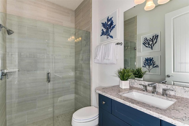 bathroom featuring vanity, toilet, and a shower with shower door