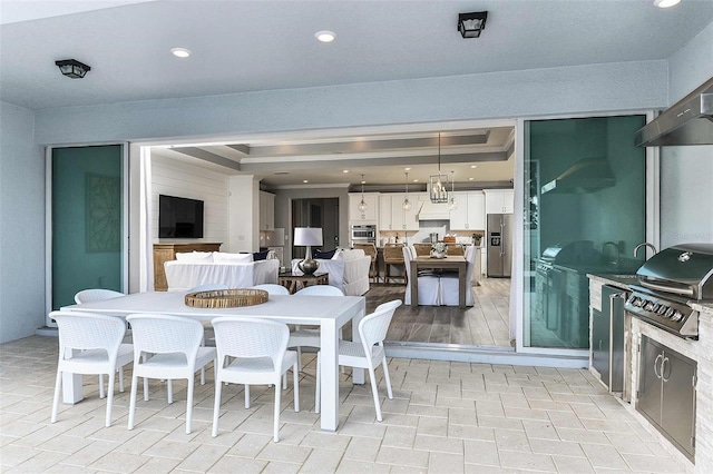 dining space with a tray ceiling and light hardwood / wood-style floors