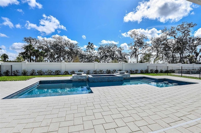 view of pool featuring a patio area and an in ground hot tub