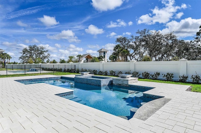 view of pool featuring a patio and an in ground hot tub