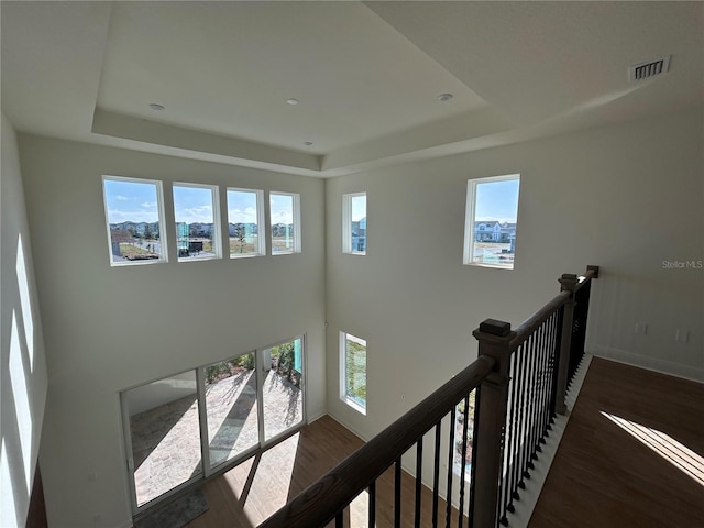 hallway featuring a raised ceiling and hardwood / wood-style floors