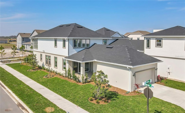 view of front of home featuring a garage, a shingled roof, concrete driveway, a residential view, and a front lawn