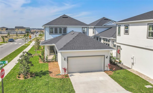 traditional-style home with a shingled roof, concrete driveway, an attached garage, a residential view, and a front lawn