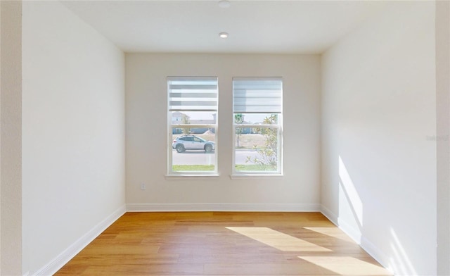 empty room with light wood-style flooring and baseboards