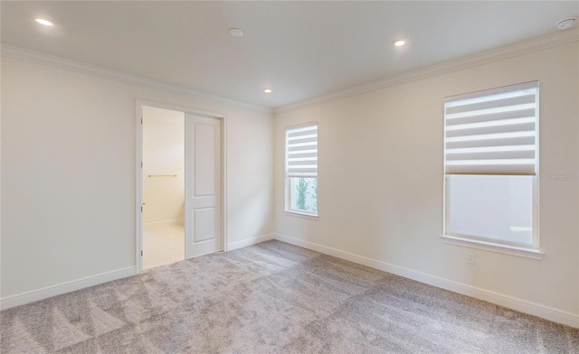 empty room featuring ornamental molding, recessed lighting, light colored carpet, and baseboards