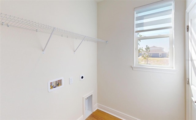 laundry room with hookup for a washing machine, hookup for an electric dryer, laundry area, wood finished floors, and baseboards