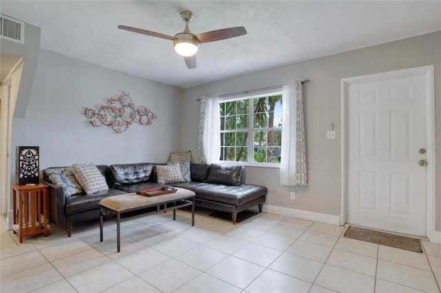 tiled living room with a textured ceiling and ceiling fan