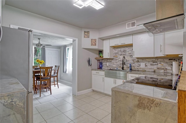 kitchen featuring sink, white cabinetry, decorative backsplash, ceiling fan, and stainless steel fridge