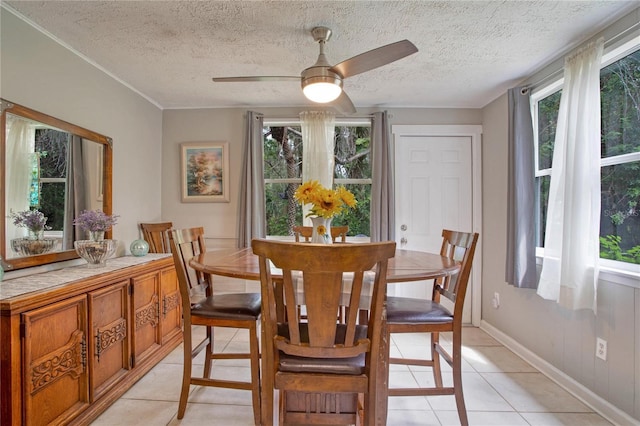 tiled dining space with ceiling fan, a textured ceiling, and plenty of natural light