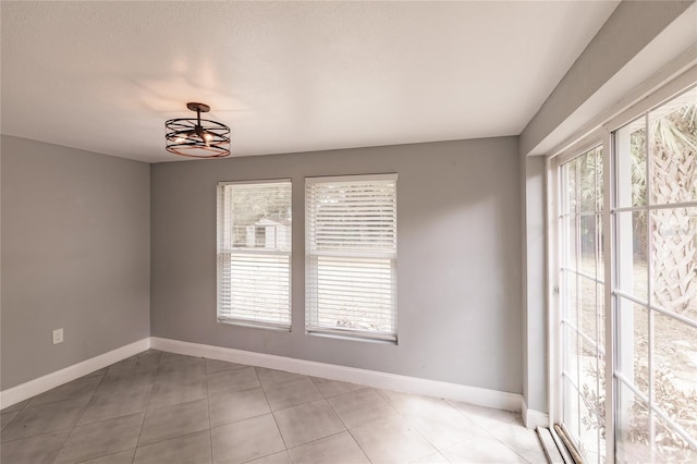 unfurnished room with baseboards and light tile patterned flooring