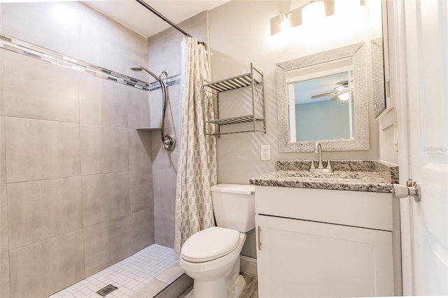 bathroom featuring a shower with shower curtain, ceiling fan, vanity, and toilet