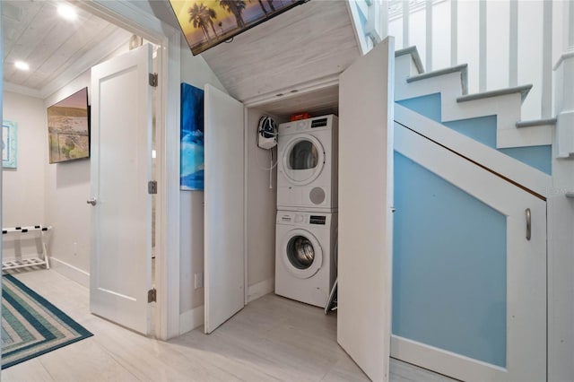 clothes washing area with stacked washing maching and dryer