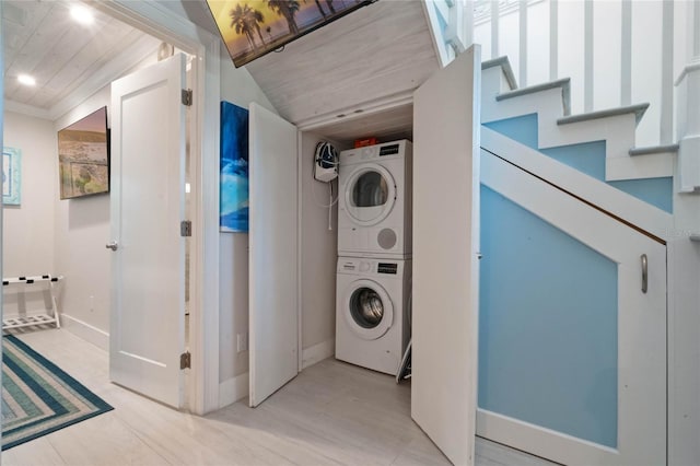 laundry room with stacked washer and dryer, baseboards, and laundry area