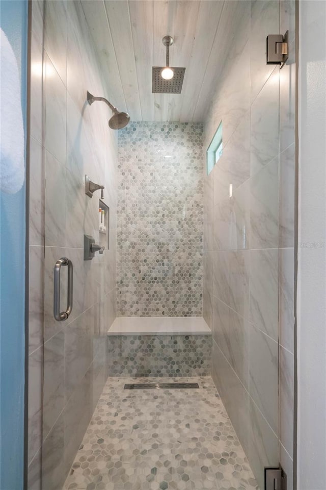 bathroom featuring a shower with door and wooden ceiling