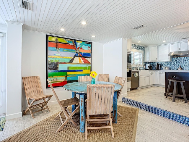 dining room featuring wood ceiling, light hardwood / wood-style flooring, and ornamental molding