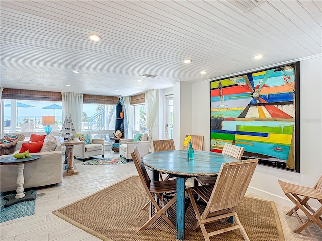 dining space featuring light wood-type flooring and wood ceiling