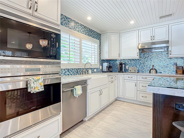 kitchen with light wood-type flooring, tasteful backsplash, stainless steel appliances, and white cabinets