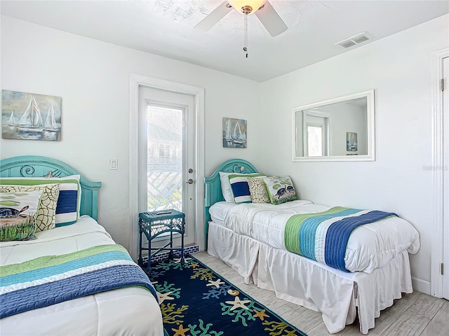 bedroom featuring light wood-type flooring, multiple windows, ceiling fan, and access to exterior