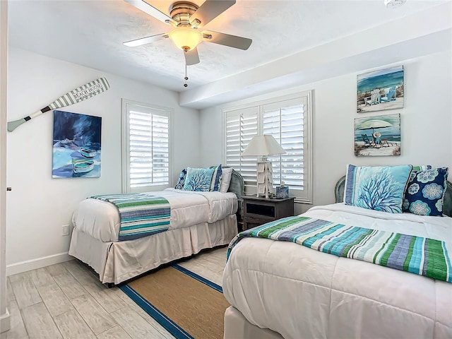 bedroom with baseboards, light wood finished floors, and ceiling fan